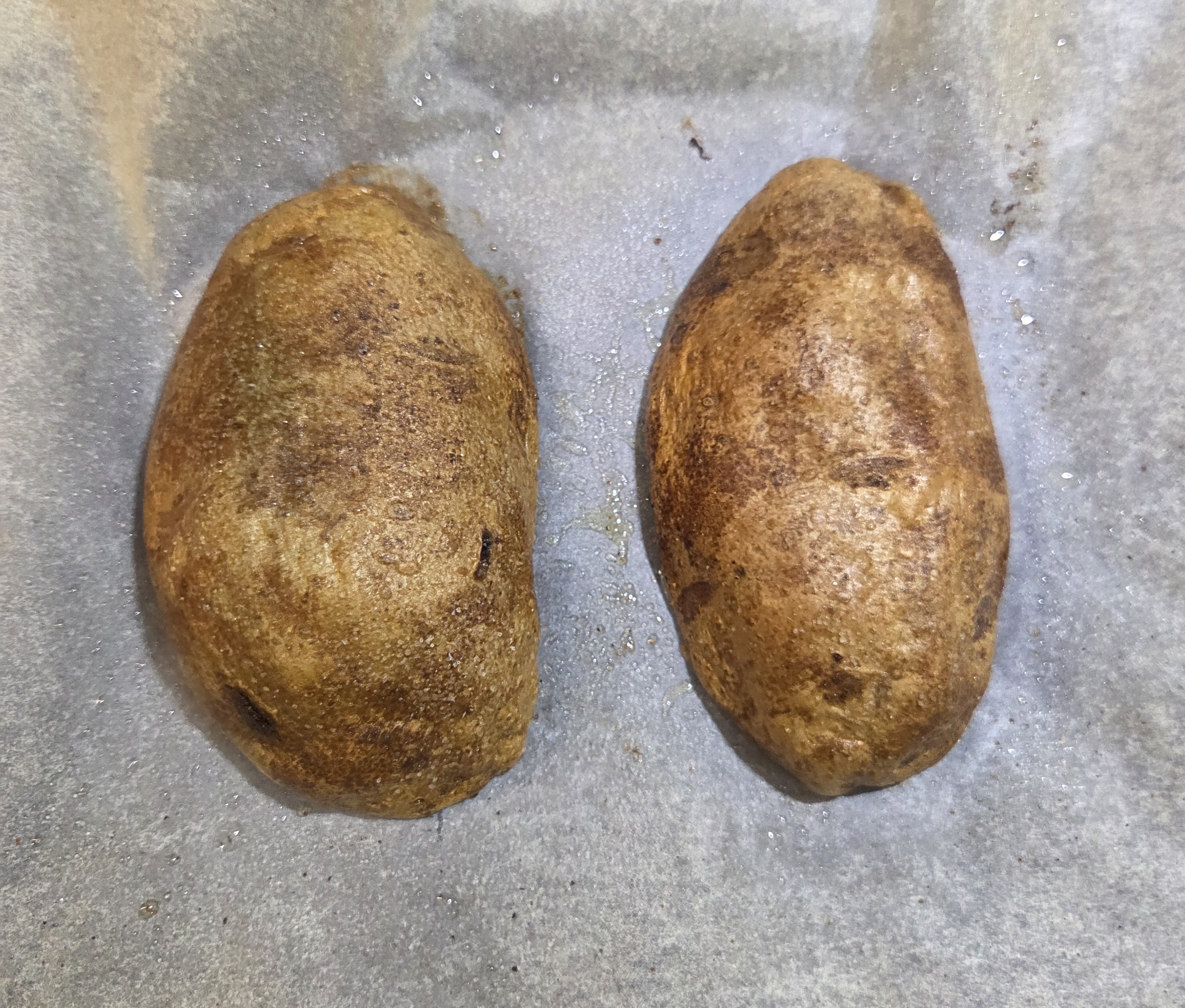 Perfectly baked potatoes just out of the oven, skin side up